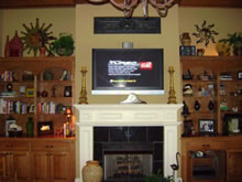 Flat screen TV above the fireplace.