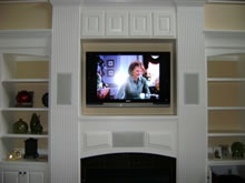 Recessed flat screen TV with recessed surround sound speakers.